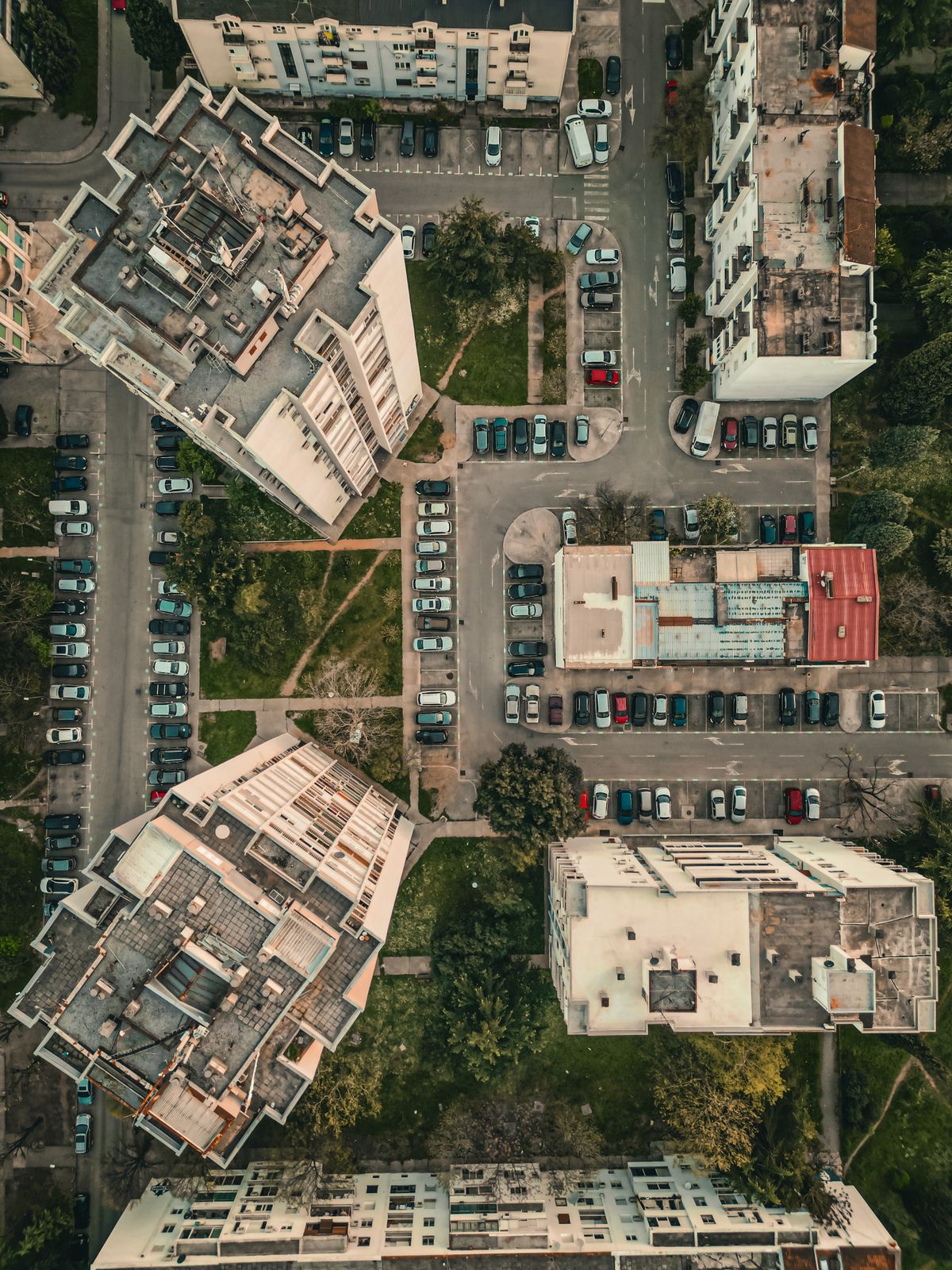 Overhead view of apartment buildings, parked cars and access lanes.