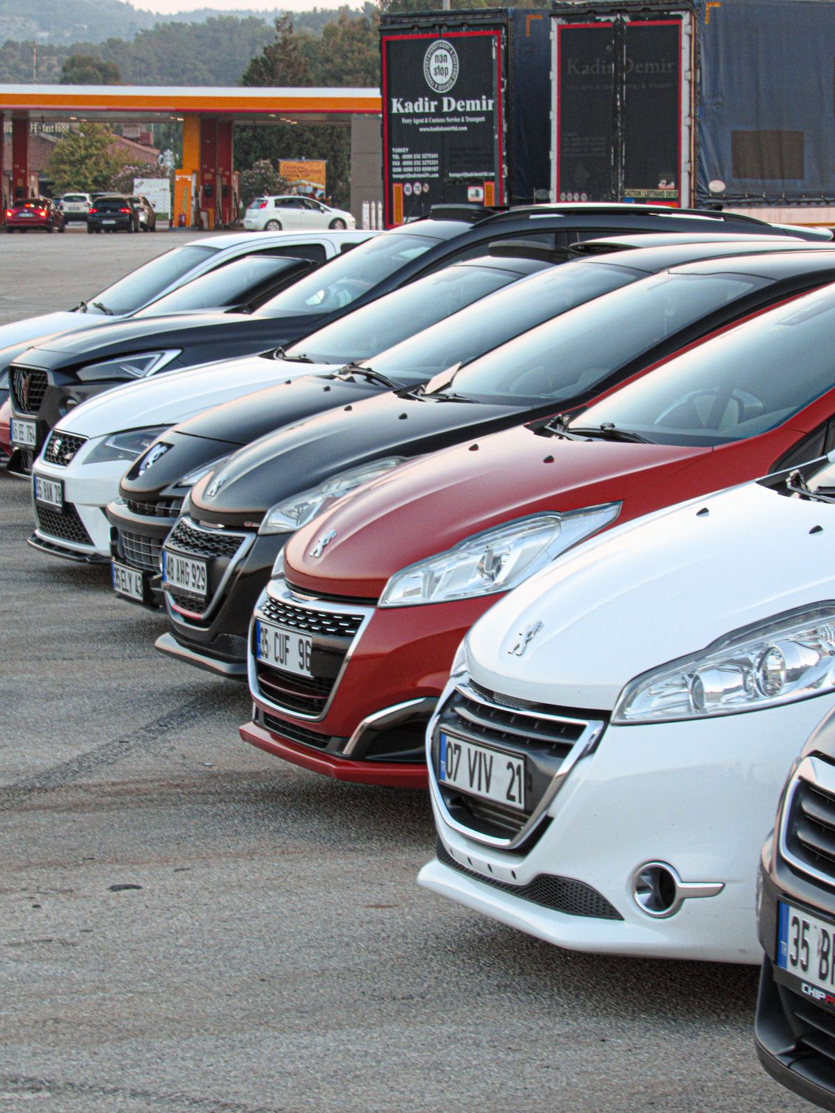 Cars lined up on a paved dealership lot.