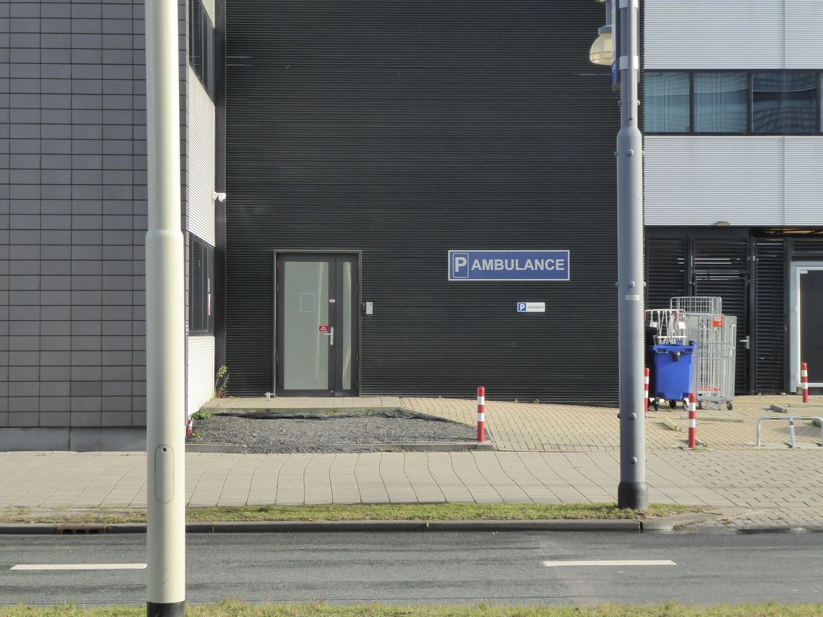 Hospital access road with marked ambulance parking.