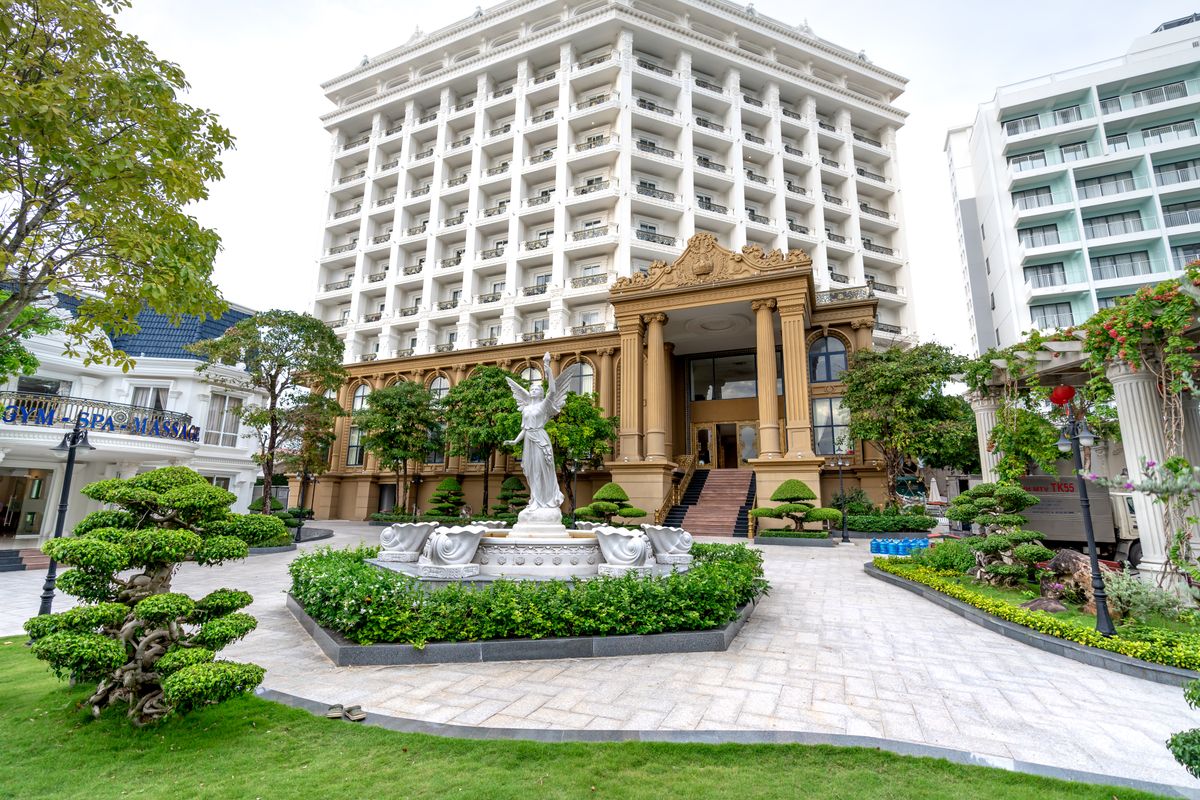 Hotel entrance with landscaped grounds and a paved approach.