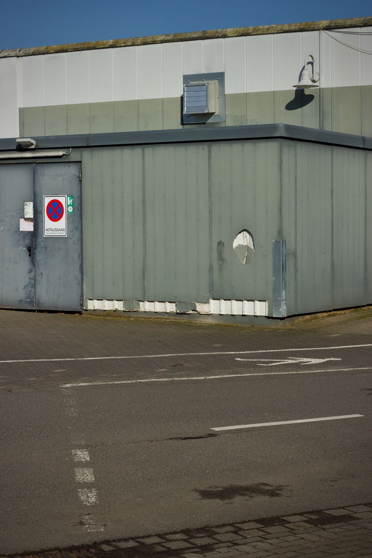 Industrial building beside a paved service area.