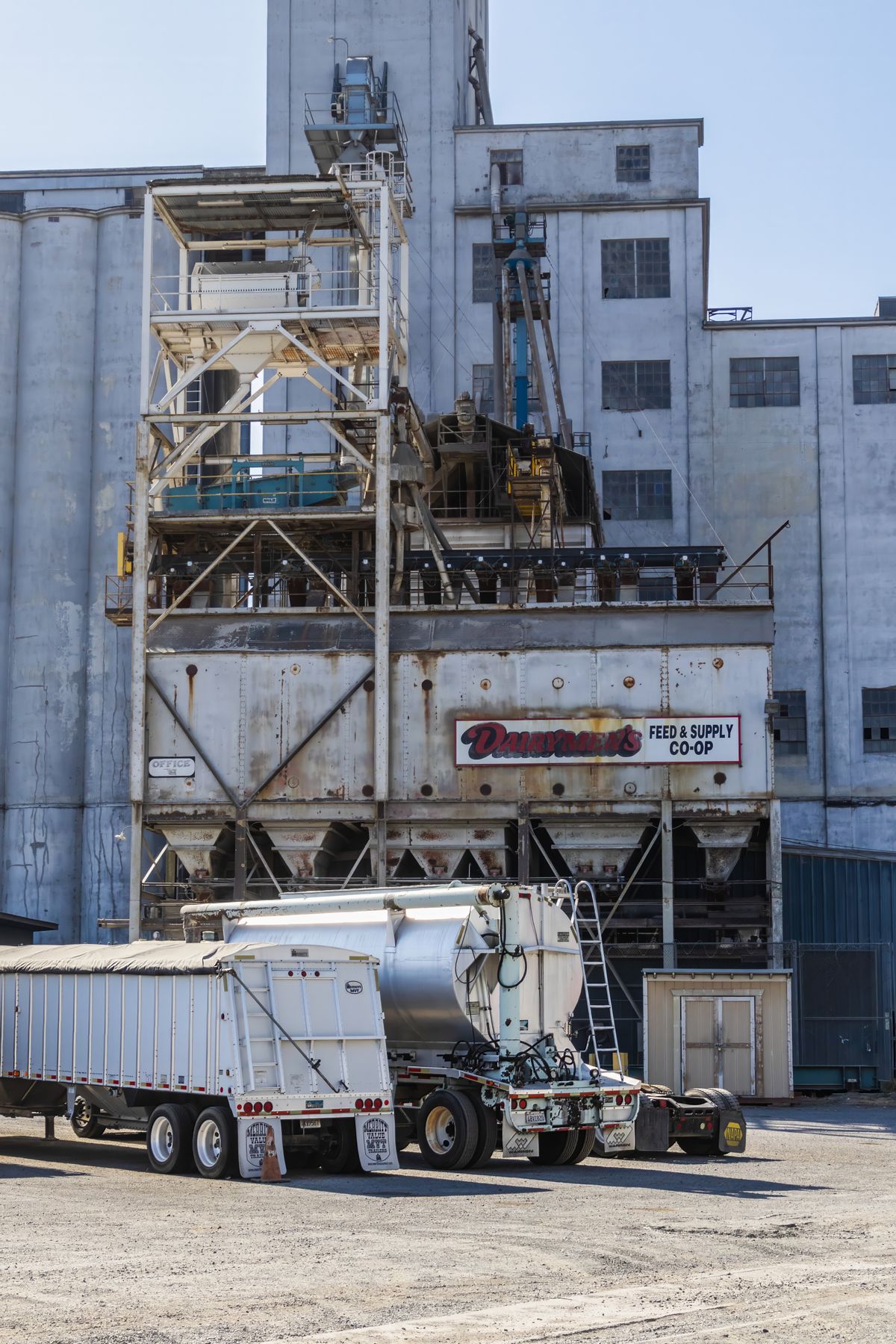 Truck trailers beside an industrial loading facility.