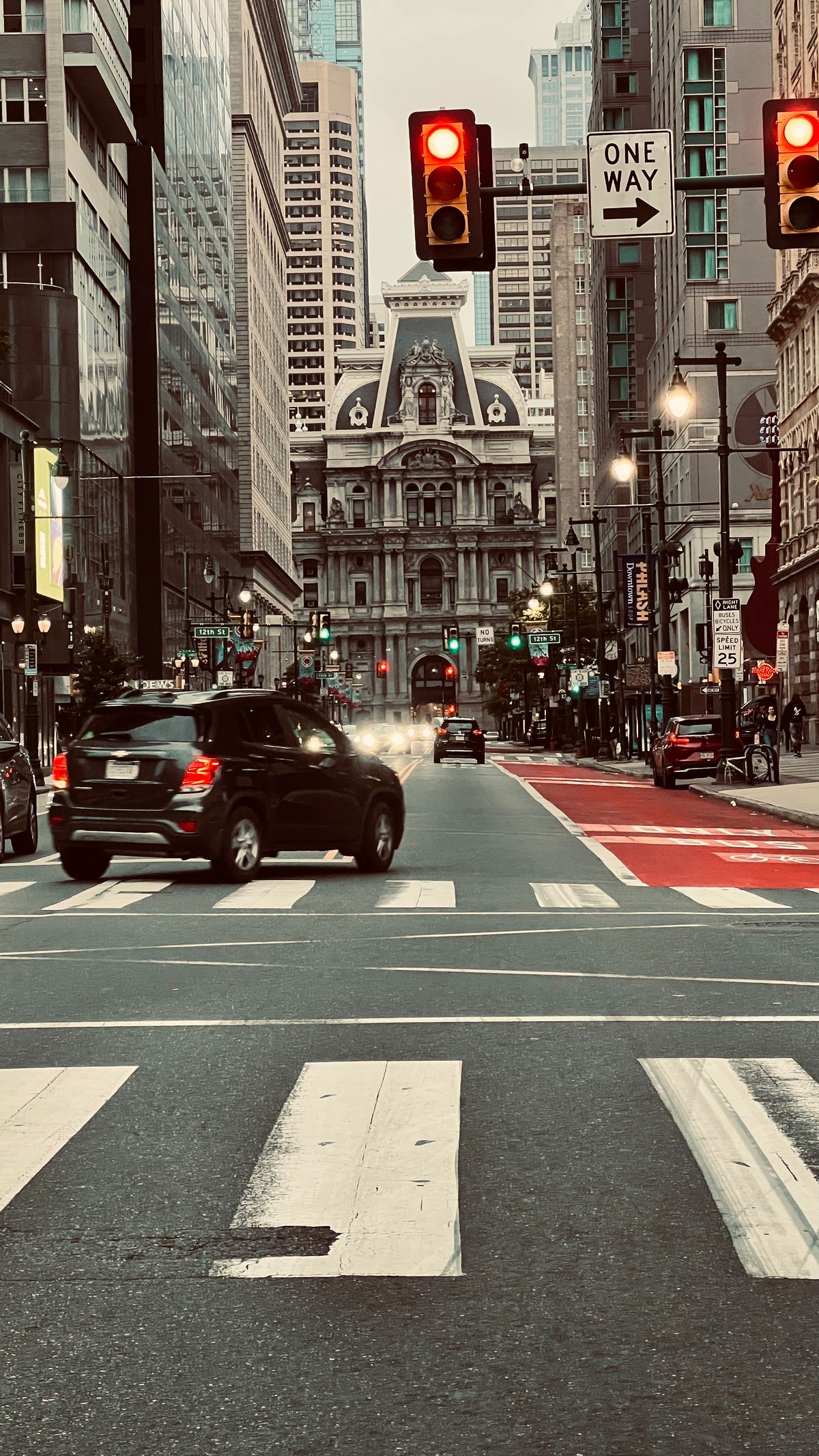 Urban roadway with a pedestrian crossing and civic buildings.