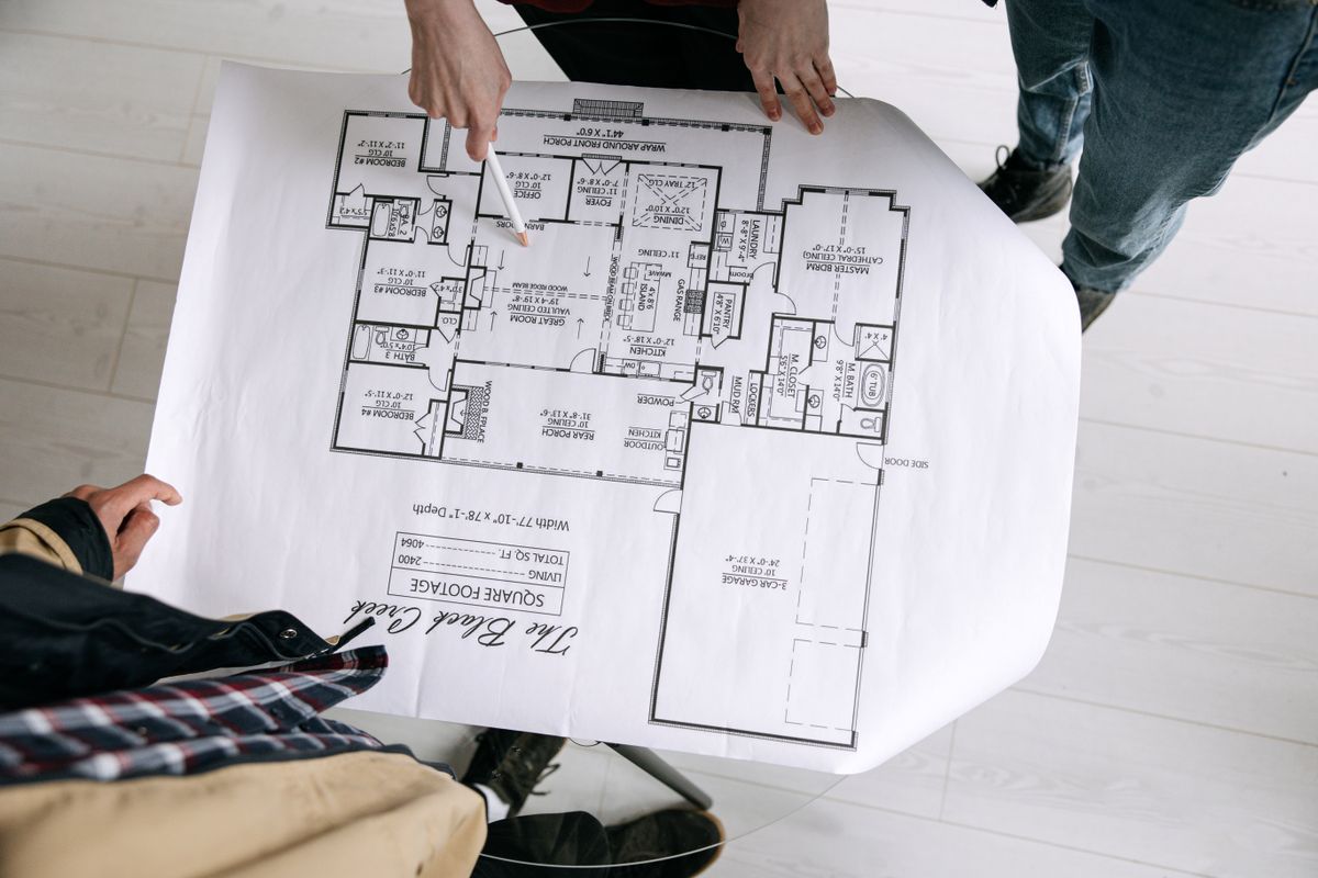 People reviewing a large building plan on a table.