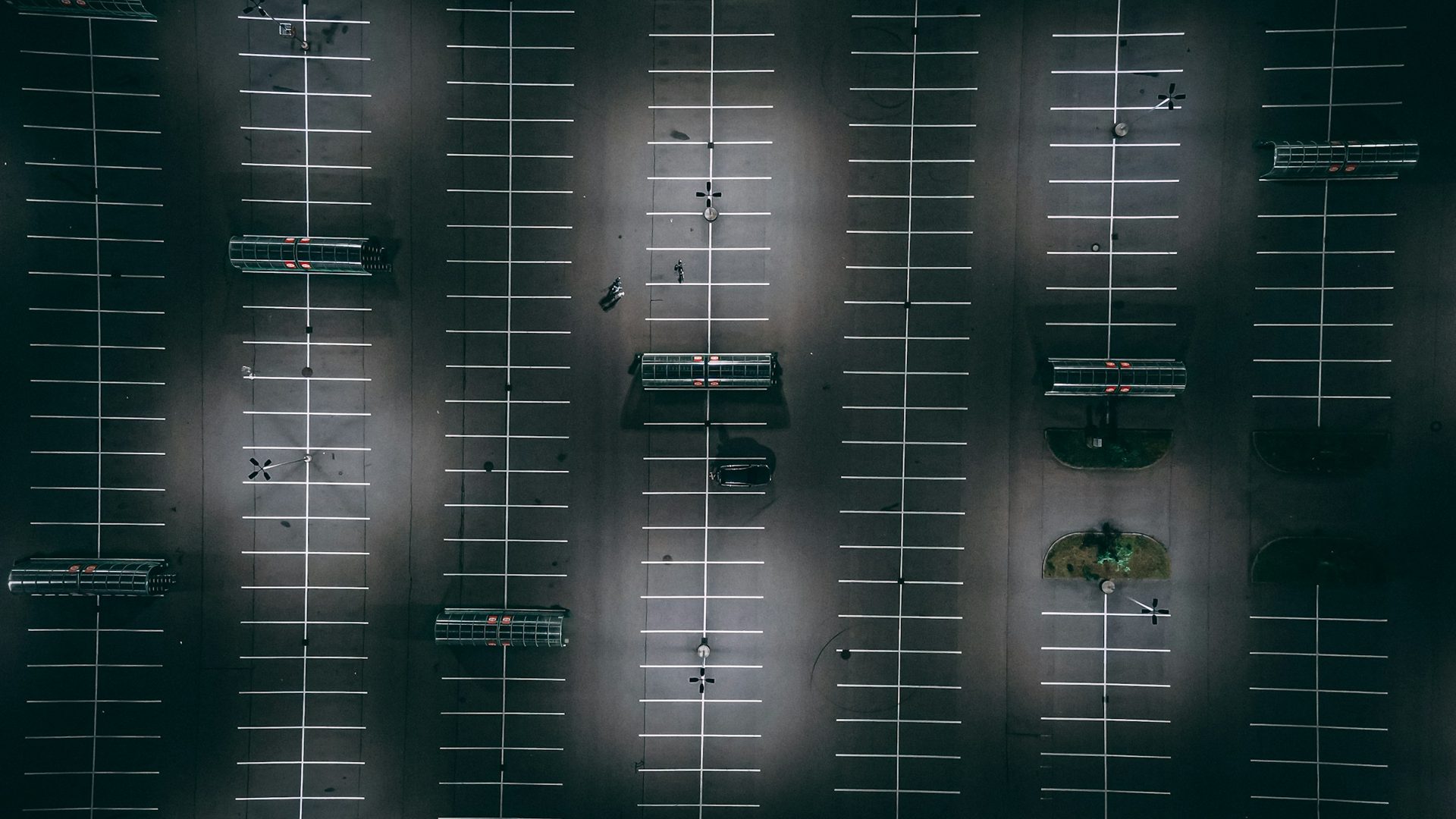 Aerial view of asphalt parking spaces with white pavement markings