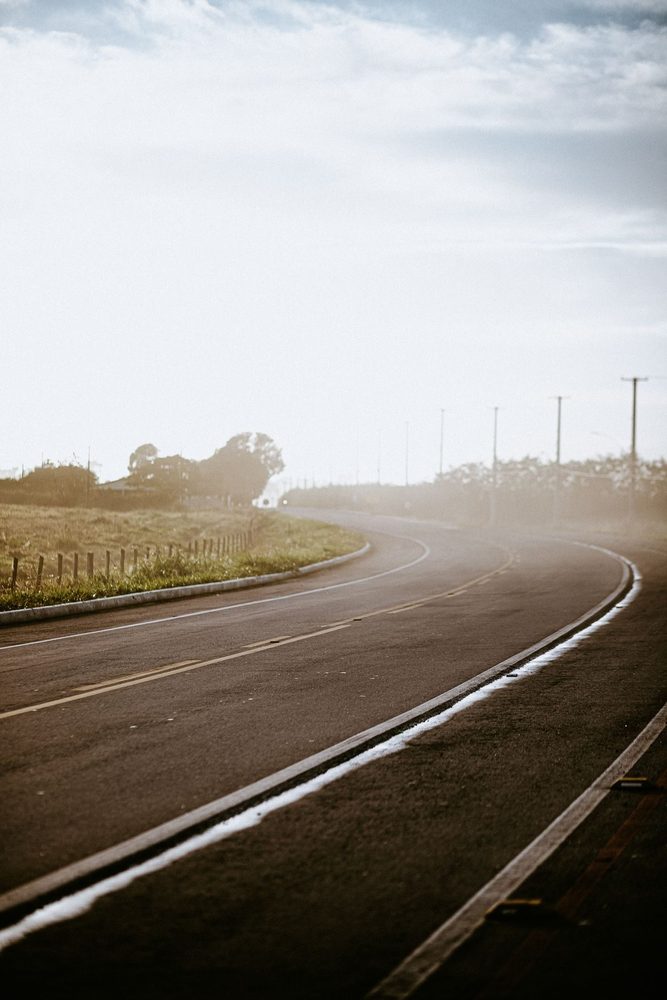 Curving asphalt road with white edge markings.