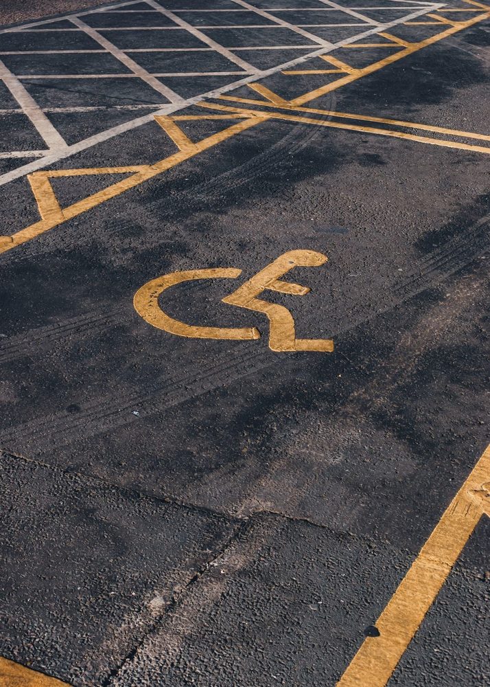 Yellow accessible parking symbol and hatched pavement markings.