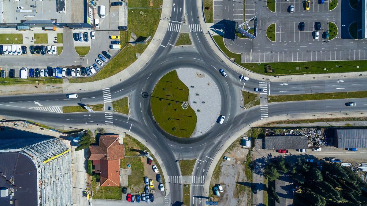 Aerial view of a paved roundabout and its connecting lanes.