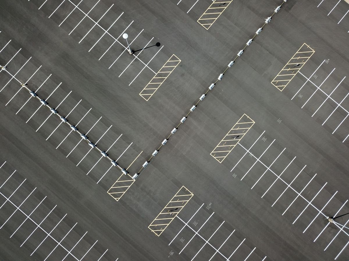 Overhead view of white parking lines across a large asphalt lot.