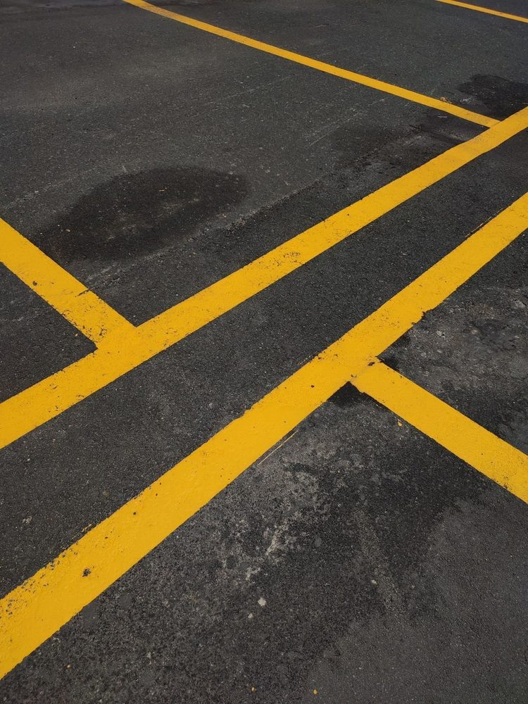 Yellow parking lines on a dark asphalt surface.