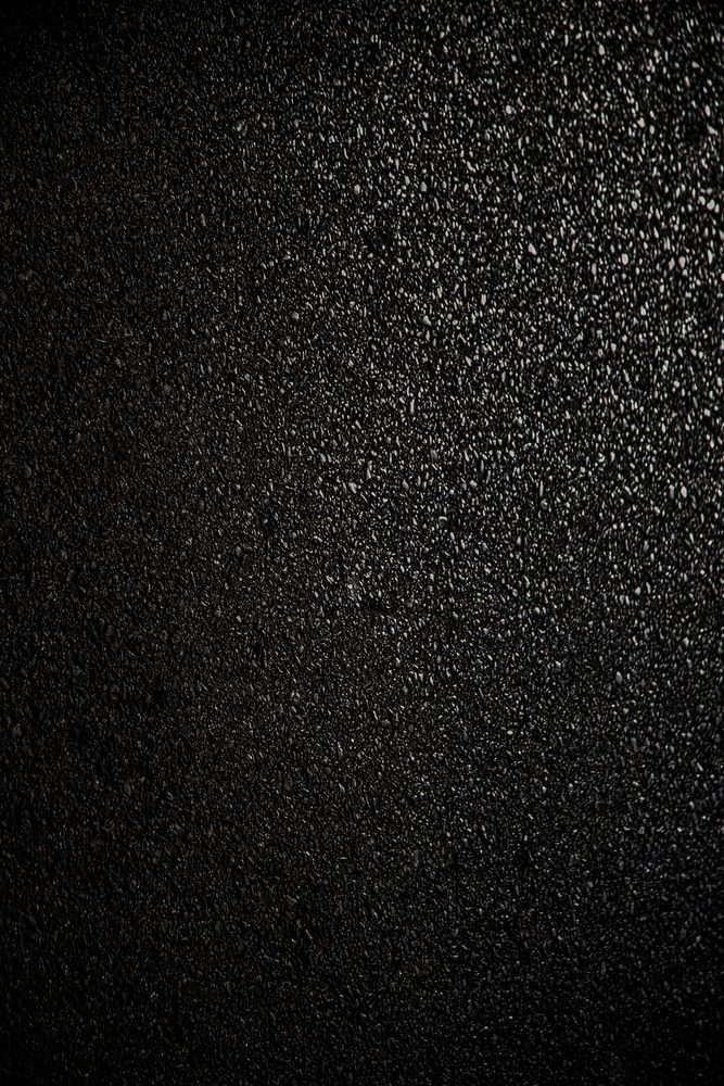 Dark asphalt surface with a fine granular texture.