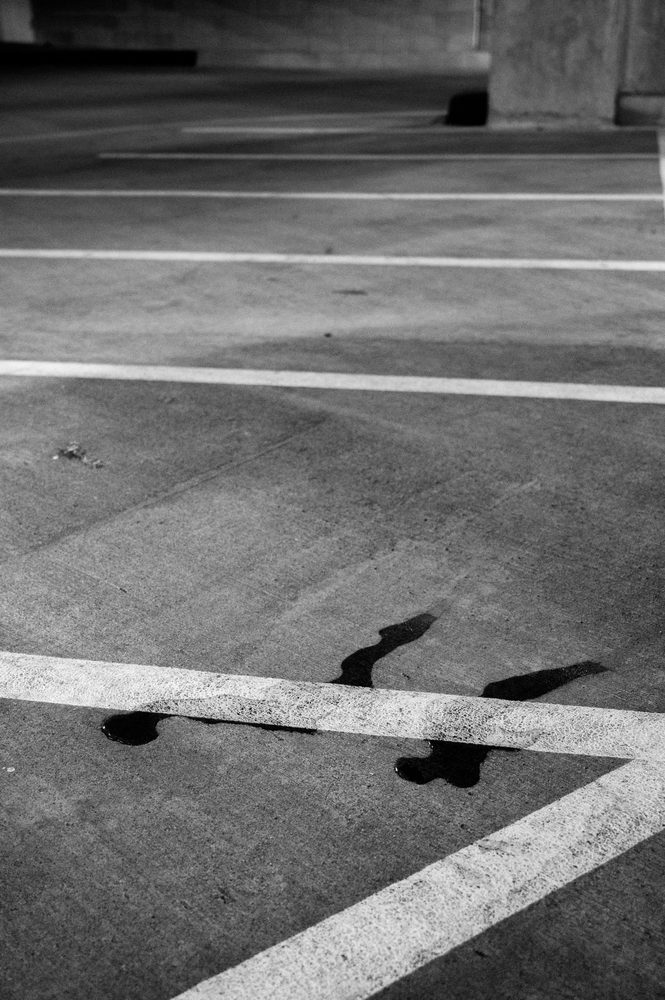 White parking lines and surface stains on asphalt.