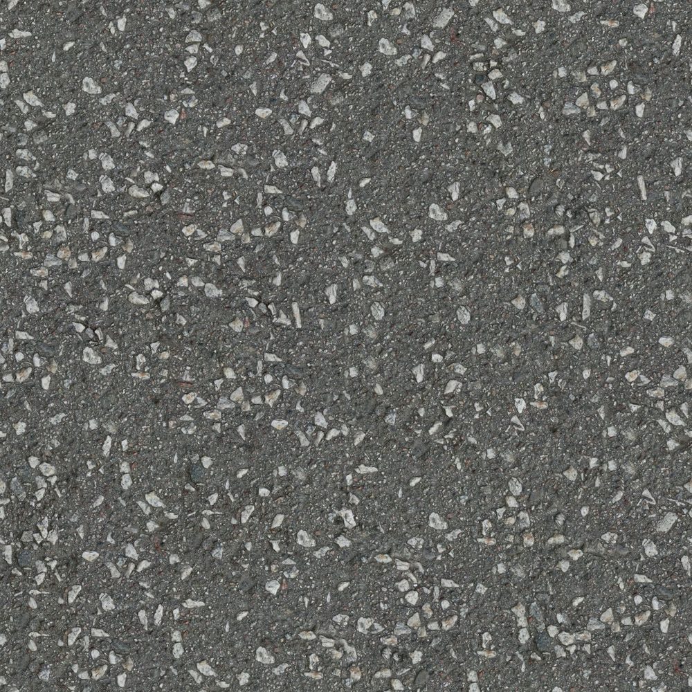 Close view of aggregate embedded in an asphalt surface.