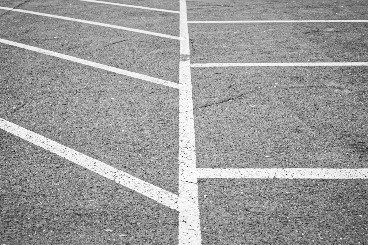 White hatched lines and parking bays on textured asphalt.