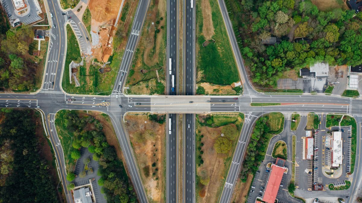 Aerial view of paved intersections and a highway overpass.