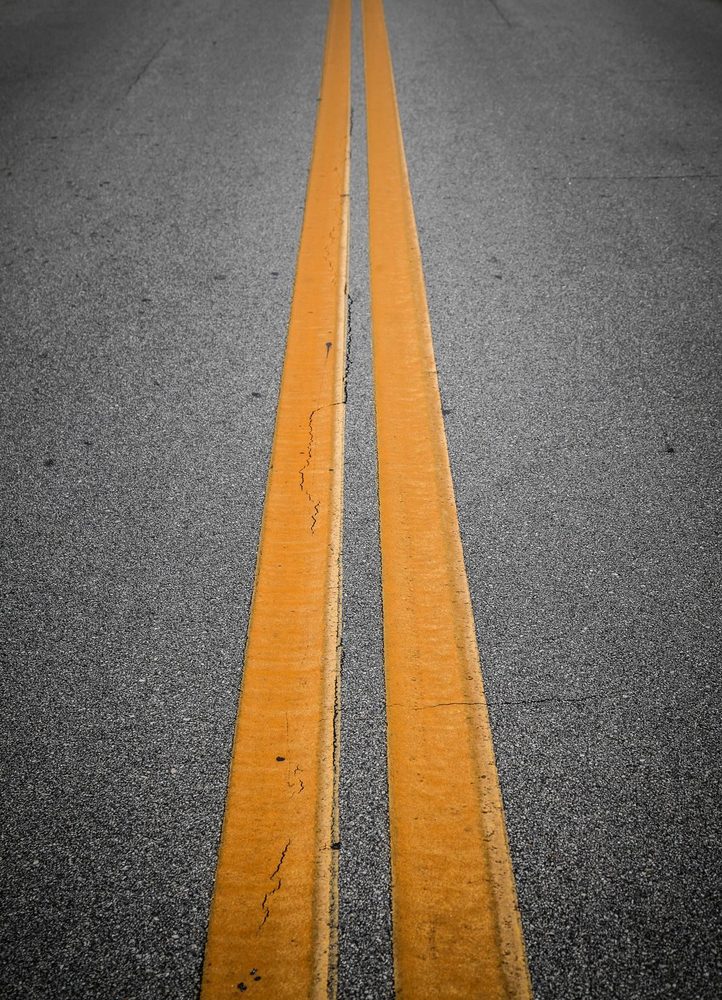 Double yellow centre lines on a paved road.