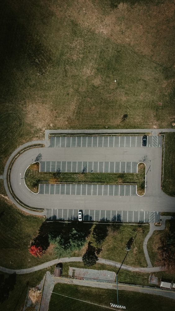Aerial view of a paved parking area bordered by grass.