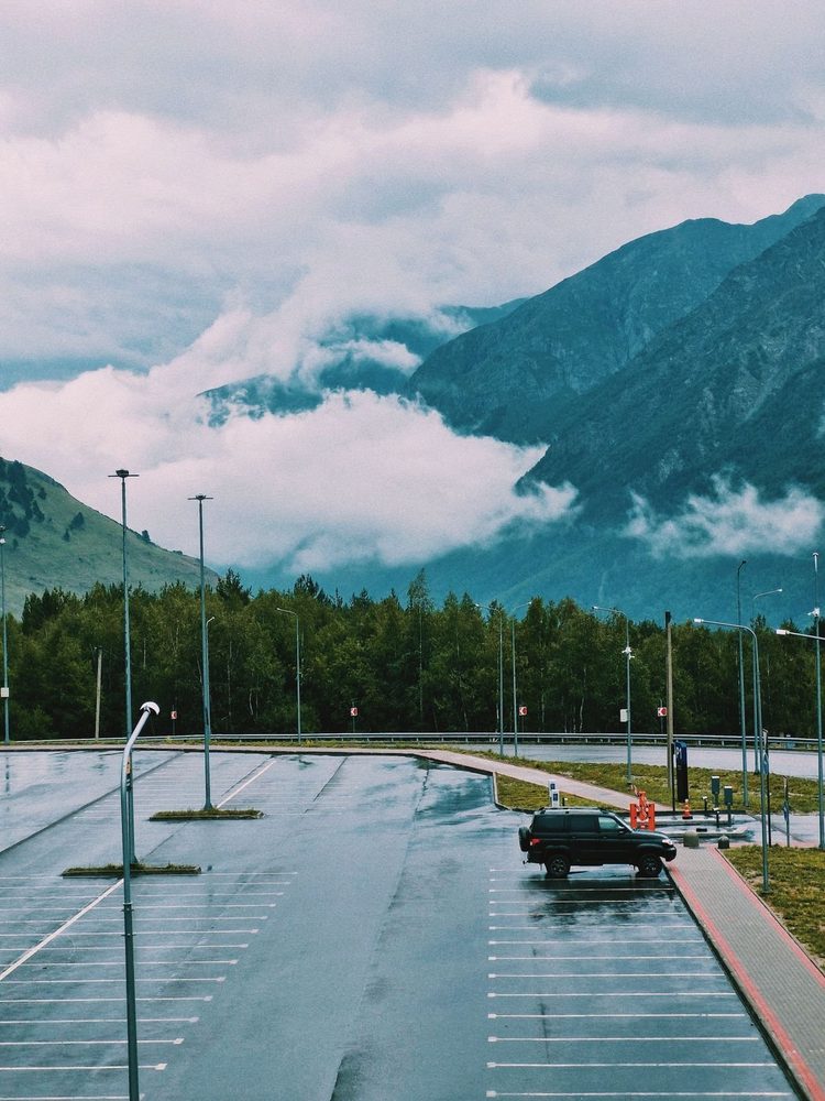 Wet marked parking surface with mountains in the distance.