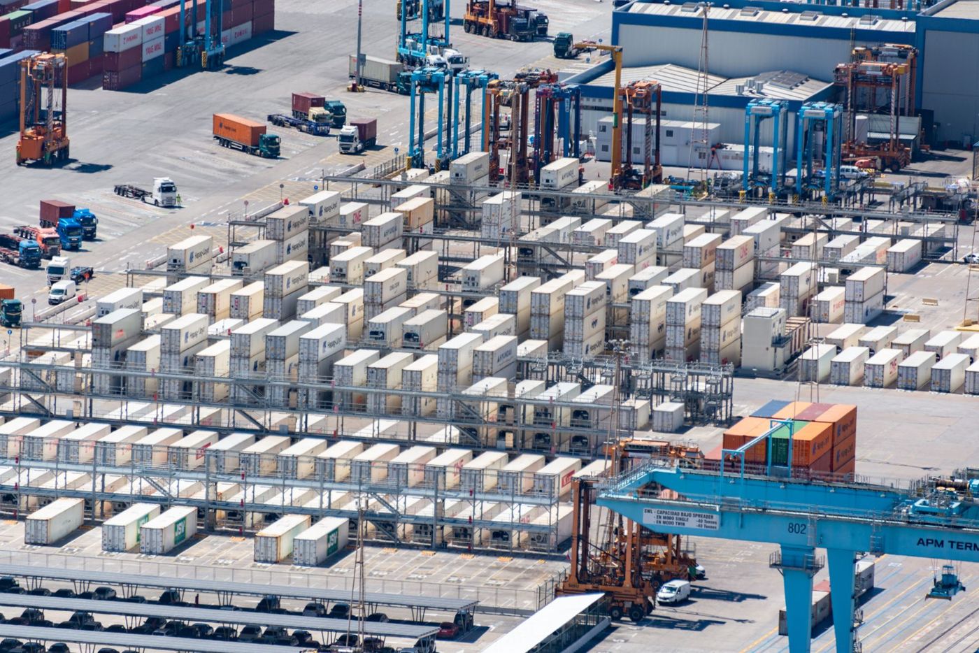 Industrial logistics yard with shipping containers and trucks.