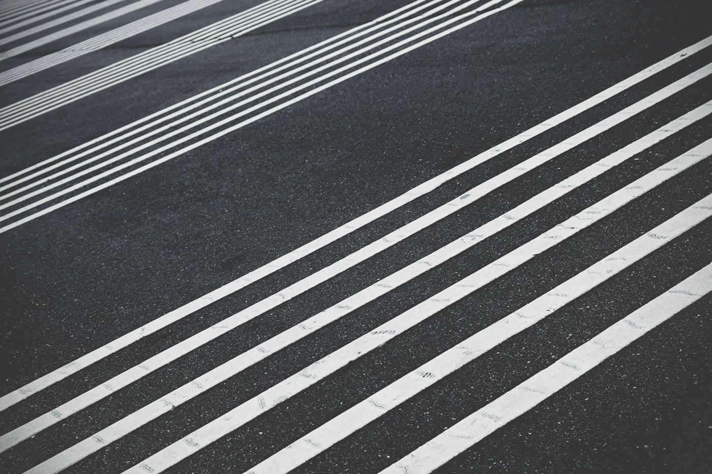Parallel white painted lines on dark asphalt.