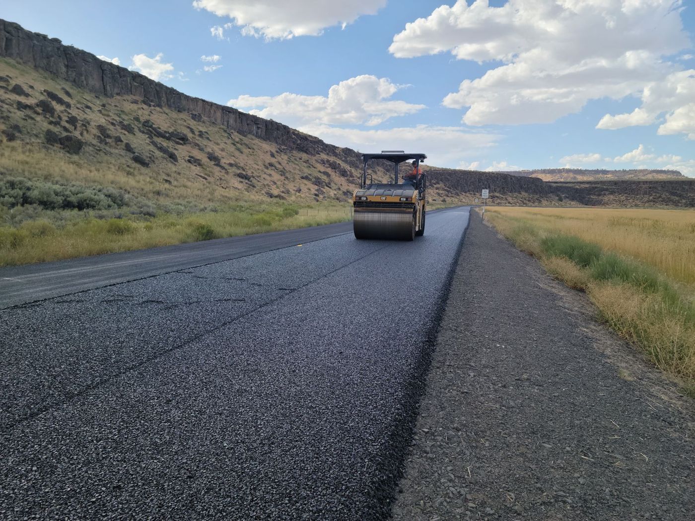 Road roller on an asphalt roadway.